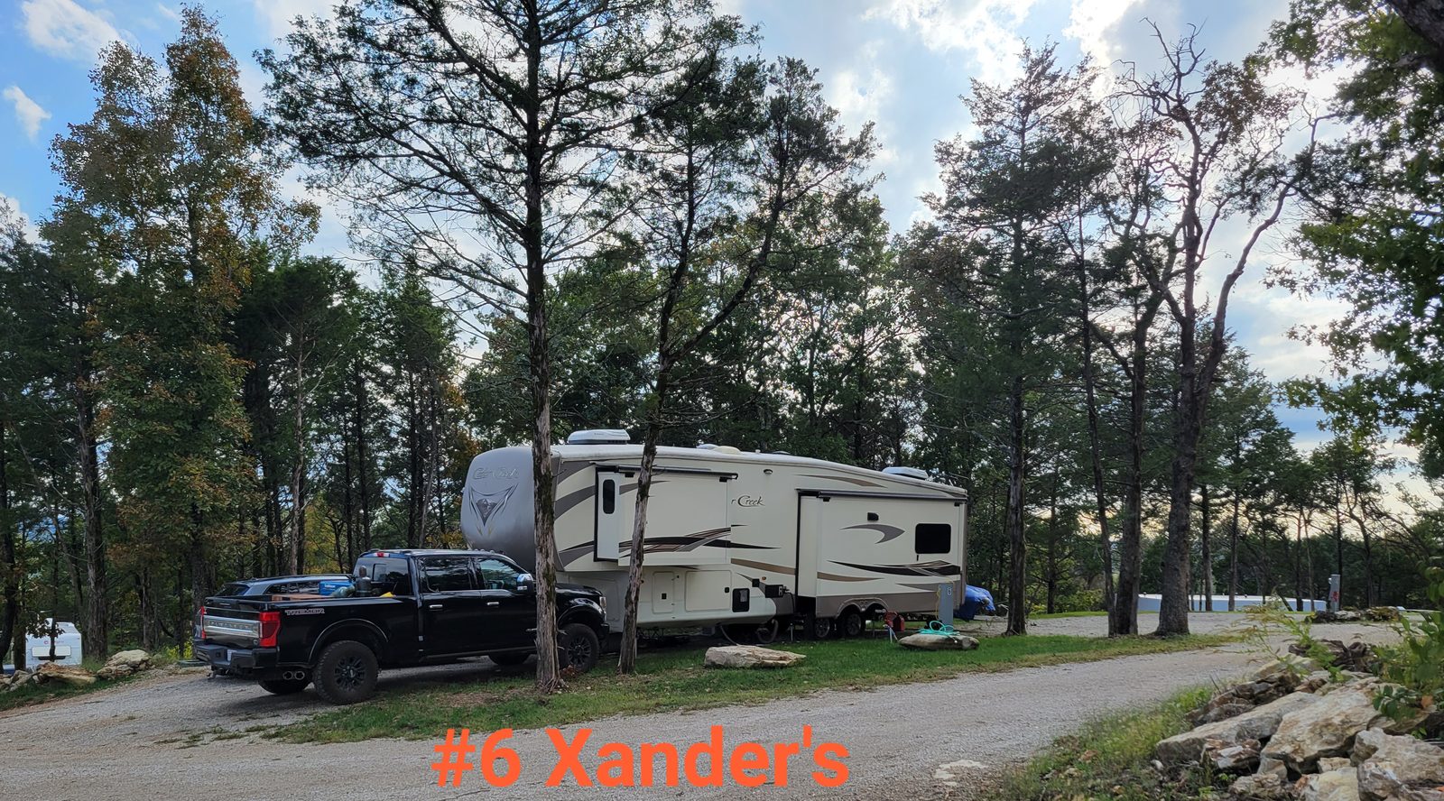 Waterfront-view site 6 with a large RV and open sky.