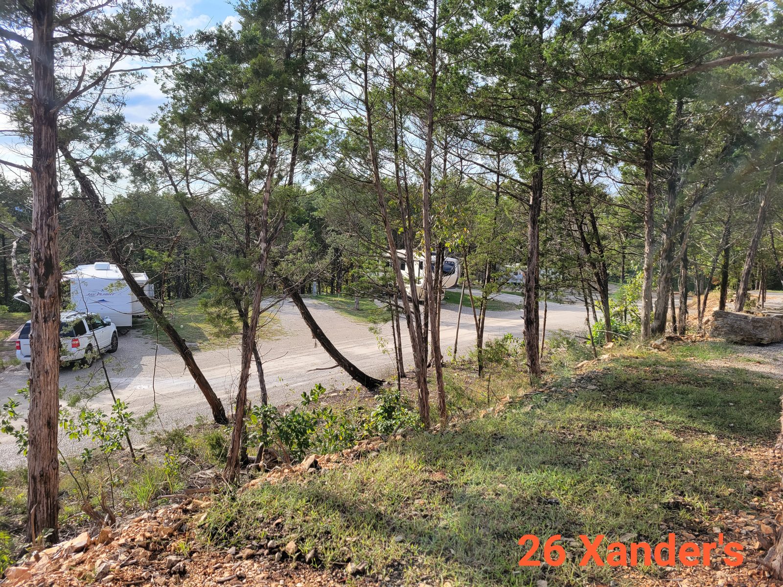 Level full-hookup RV site 26 among shade trees.